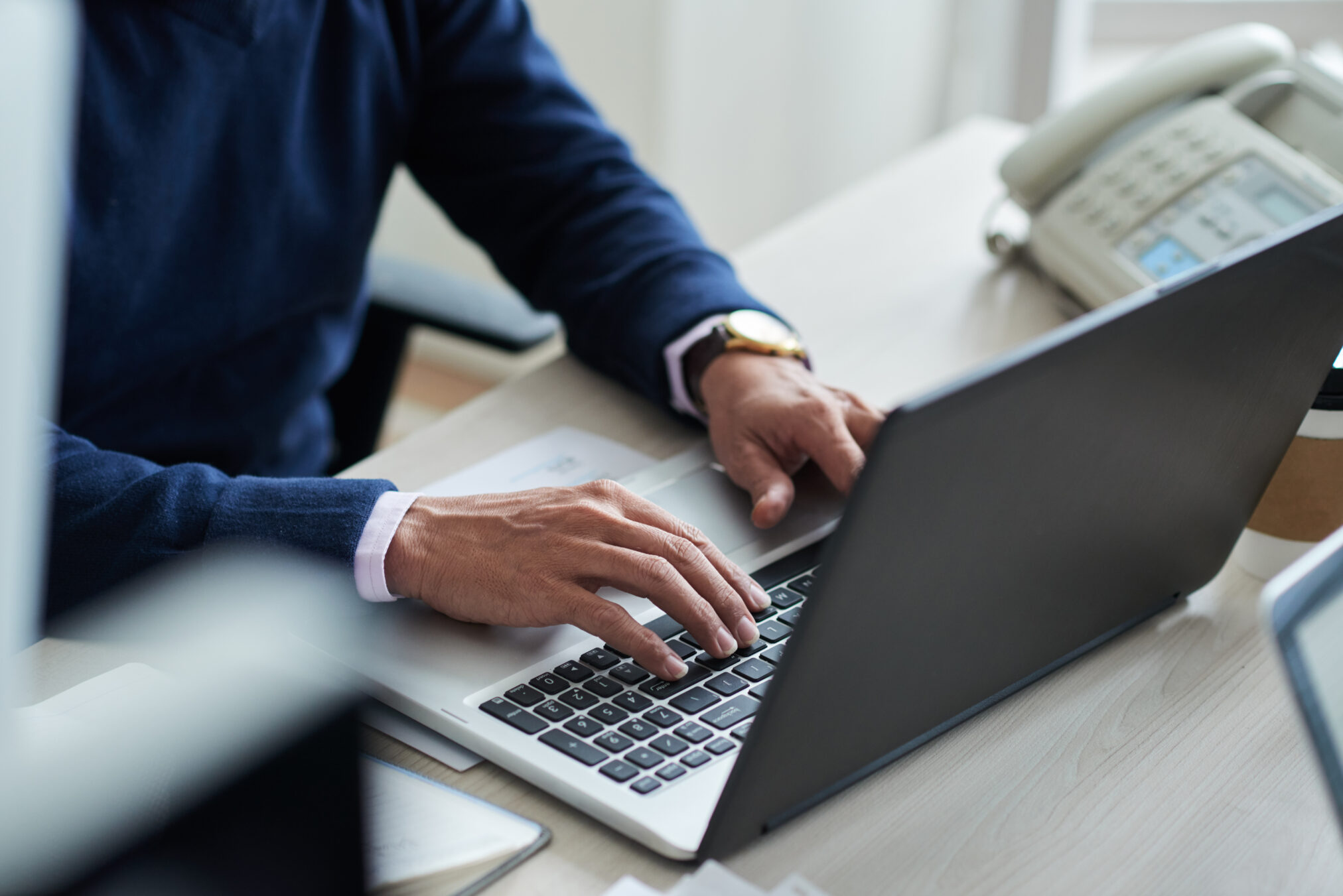 Close-up image of businessman typing on laptop at his workplace
